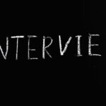 Chalkboard writing of 'Interview' on a sleek black background, perfect for business themes.