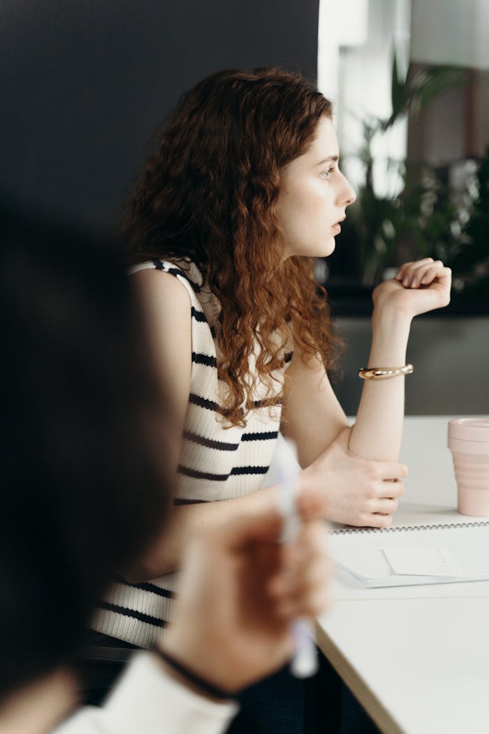 Focused businesswoman attentively listening during a meeting in a modern office.